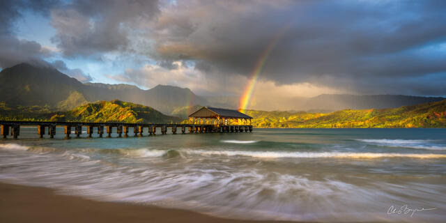 A rainbow kisses the pier in Hanalei Bay on Kauai
