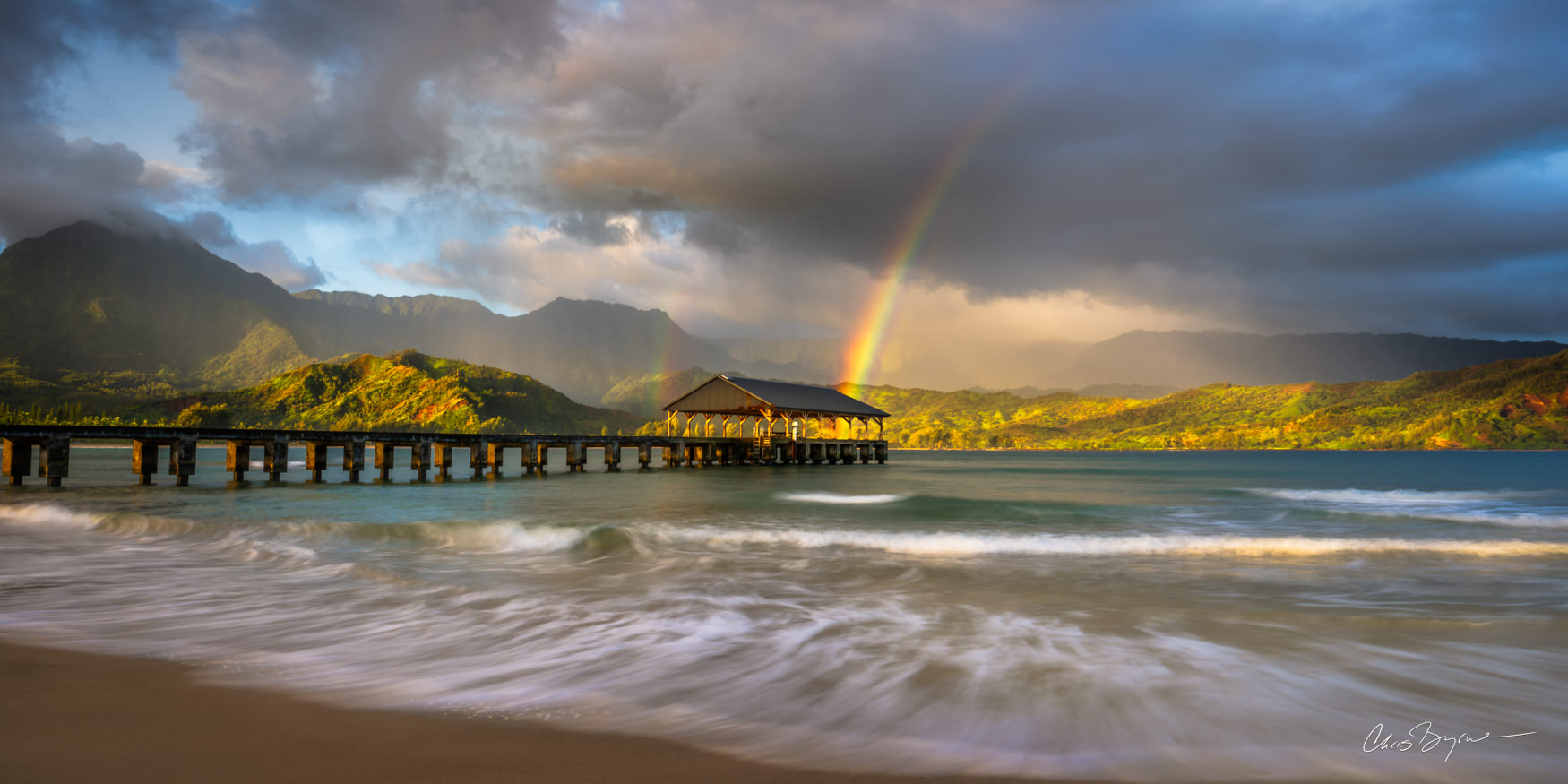 MOMENTARY BLISS A rainbow kisses the pier in Hanalei Bay on Kauai