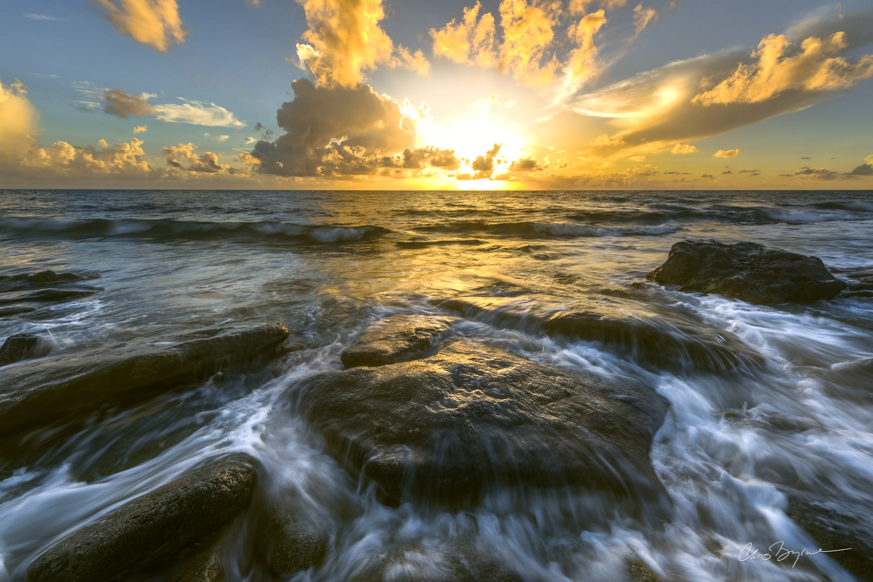 DAYBREAK Waves rush in over the rocks at sunset where this rocky shore meets teh ocean.